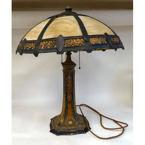 269 - An Arts & Crafts painted metal table lamp with a tapered column, on a decoratively formed base, ... 