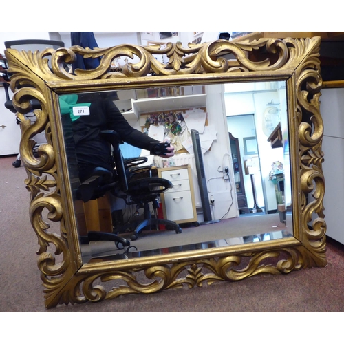 271 - A 19thC mirror with a later bevelled plate, set in a carved giltwood scrolled frame  26