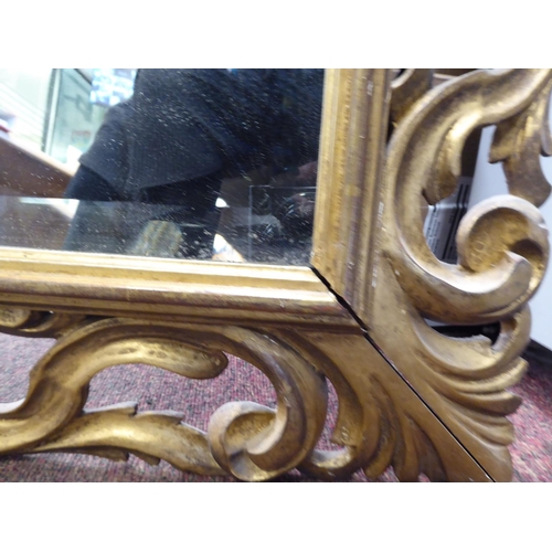 271 - A 19thC mirror with a later bevelled plate, set in a carved giltwood scrolled frame  26