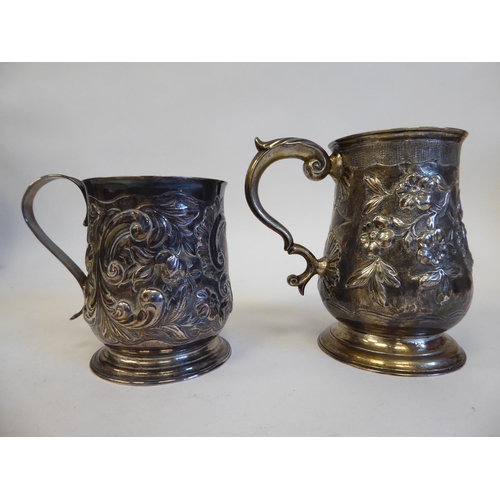 274 - A George II silver mug with an S-shape handle, embossed and scrolled ornament  Elizabeth Goodwi... 