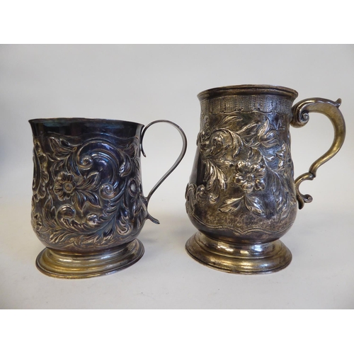 274 - A George II silver mug with an S-shape handle, embossed and scrolled ornament  Elizabeth Goodwi... 