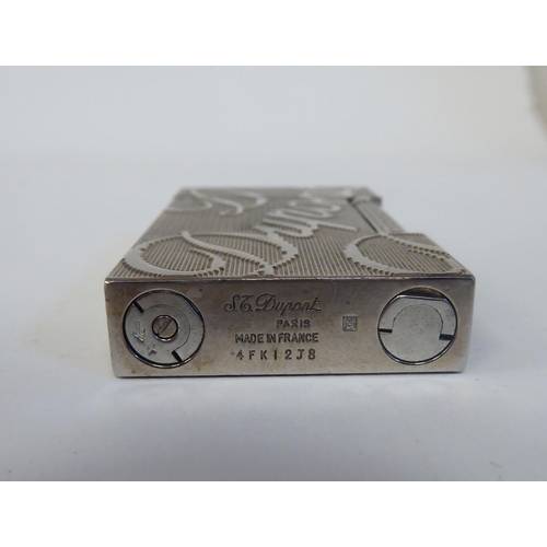 285 - A Dupont rectangular, stainless steel cased, gas filled cigarette lighter, decorated in large script... 