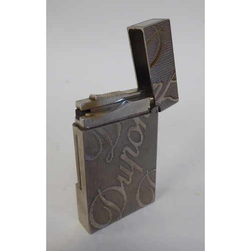 285 - A Dupont rectangular, stainless steel cased, gas filled cigarette lighter, decorated in large script... 