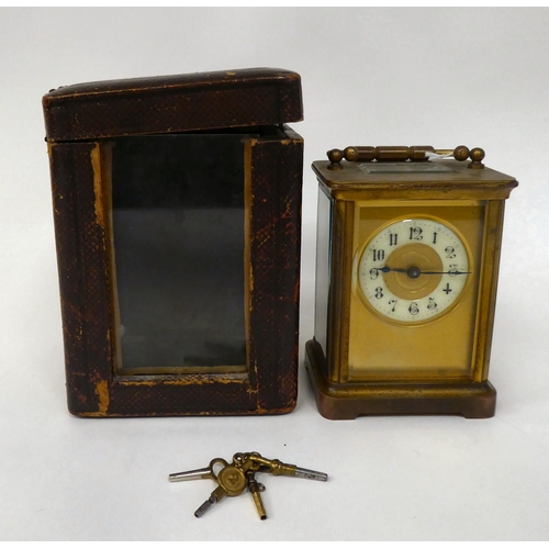 287 - A mid 20thC brass cased carriage timepiece with bevelled glass panels and a folding top handle; the ... 