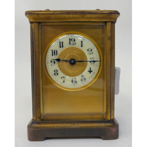 287 - A mid 20thC brass cased carriage timepiece with bevelled glass panels and a folding top handle; the ... 