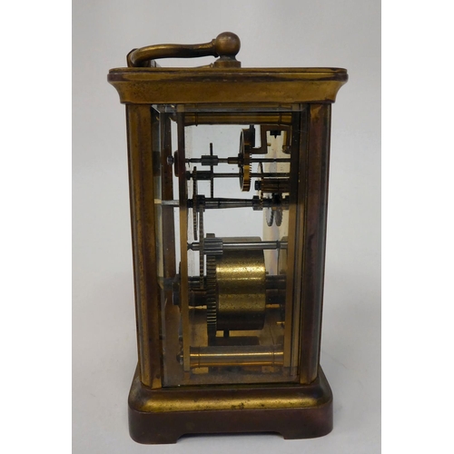 287 - A mid 20thC brass cased carriage timepiece with bevelled glass panels and a folding top handle; the ... 