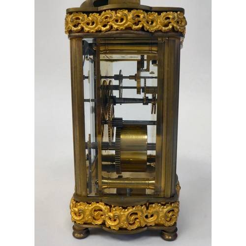 288 - A mid 20thC gilt metal cased carriage timepiece with decoratively cast frieze ornament, beaded glass... 