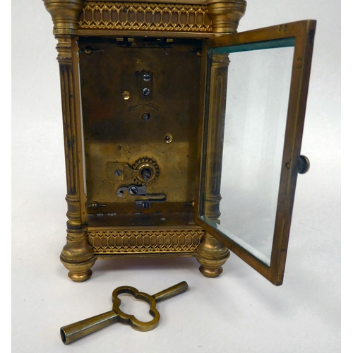 295 - A mid 20thC gilt metal cased carriage timepiece with outset pillow fretworked decoration, bevelled g... 