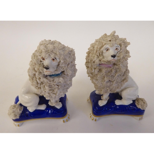 297 - A pair of mid 19thC Chelsea porcelain model lions, each seated on a pillow  3.5