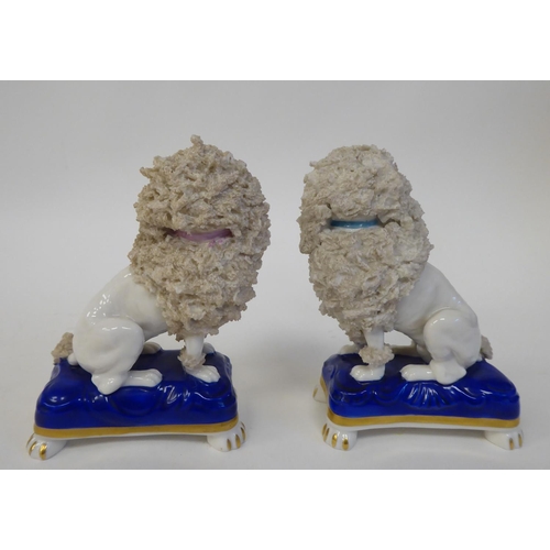 297 - A pair of mid 19thC Chelsea porcelain model lions, each seated on a pillow  3.5