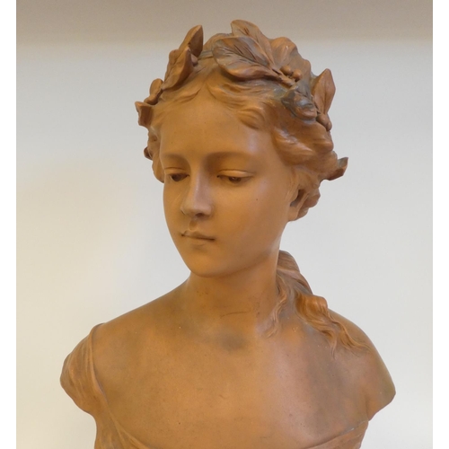 42 - An Art Nouveau terracotta bust, a young girl with fruiting vine in her hair, on a socle, incorporati... 