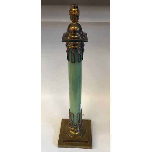 44 - An early 20thC brass table lamp incorporating an opaque, pale green glass column, on a stepped, squa... 