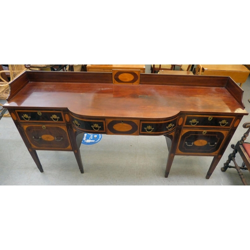 54 - A Regency Irish satinwood inlaid, mahogany breakfront sideboard with three inline drawers, above a c... 