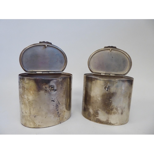 64 - A pair of Tiffany & Co Sterling silver, oval tea caddies with plain, straight sides and locking ... 