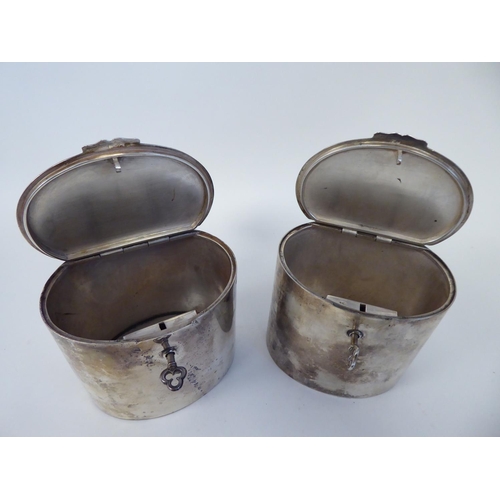 64 - A pair of Tiffany & Co Sterling silver, oval tea caddies with plain, straight sides and locking ... 