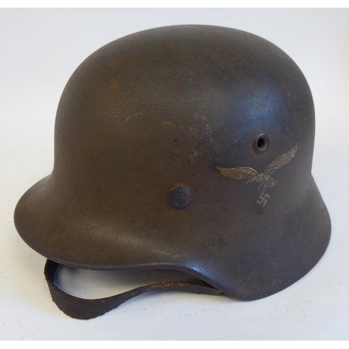 71 - A German World War II era Luftwaffe helmet with two decals, a hide liner and a buckled chinstrap(Ple... 