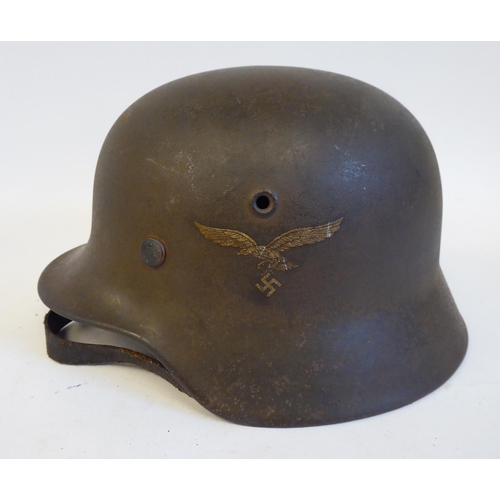 71 - A German World War II era Luftwaffe helmet with two decals, a hide liner and a buckled chinstrap(Ple... 