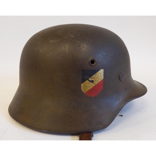 71 - A German World War II era Luftwaffe helmet with two decals, a hide liner and a buckled chinstrap(Ple... 