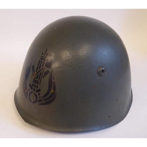 72 - An Italian grey painted steel Civil War Volunteers helmet with a hide liner and buckled chinstrap, b... 