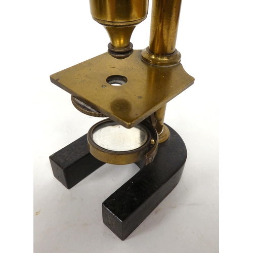 76 - A late 19thC cast iron and lacquered brass microscope with an adjustable mirror, single barrel, lens... 