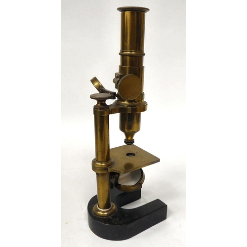 76 - A late 19thC cast iron and lacquered brass microscope with an adjustable mirror, single barrel, lens... 