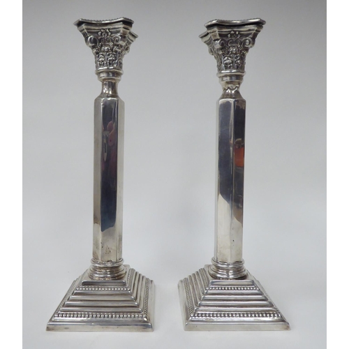 88 - A pair of Victorian silver candlesticks with bead bordered Corinthian capitals and straight, hexagon... 