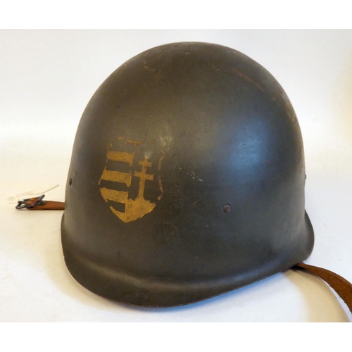 91 - A mid 20thC Eastern European dark green painted steel military helmet, bears the remnants of a paint... 