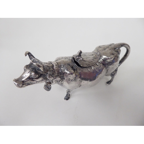 93 - A 19thC Continental silver coloured metal cow creamer, the hinged cap incorporating a bee finial, th... 