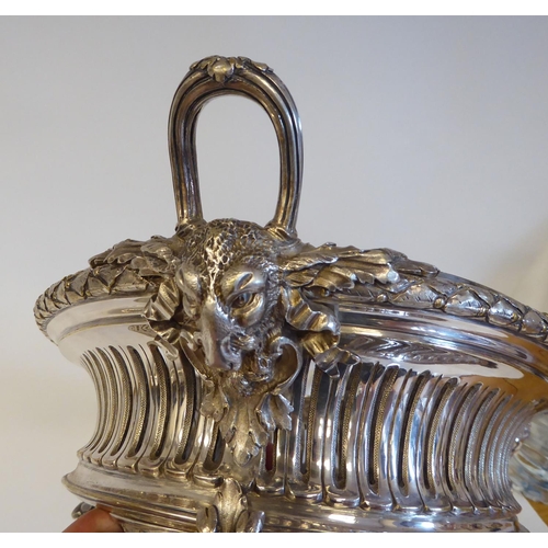 98 - An early 20thC silver plated, two-part serving dish of oval form, profusely cast with maskheads, pie... 