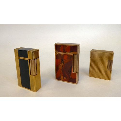 100 - Three Dupont gas filled cigarette lighters, viz. one in gilded and marble effect No.811 NSOS; anothe... 