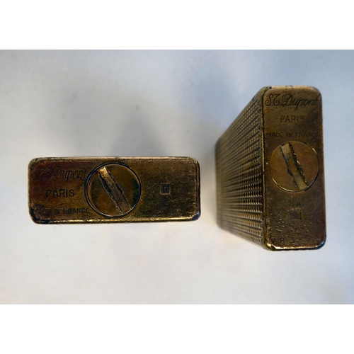 106 - A Dupont chocolate coloured and gilt cased, gas filled cigarette lighter No.5021AB; and another simi... 