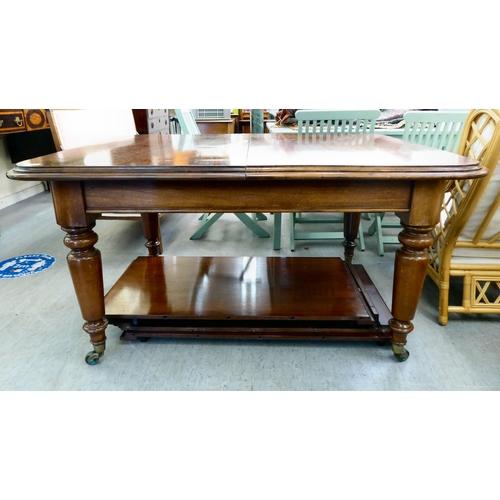 11 - A late Victorian mahogany dining table with a thumb moulded edge and rounded corners, raised on turn... 