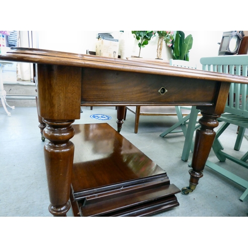 11 - A late Victorian mahogany dining table with a thumb moulded edge and rounded corners, raised on turn... 