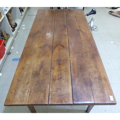 124 - A mid 19thC Continental cherrywood farmhouse table with a planked single end draw leaf, raised on sq... 