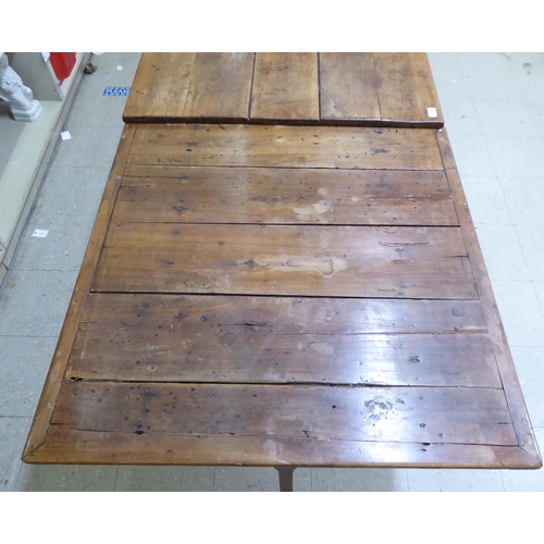 124 - A mid 19thC Continental cherrywood farmhouse table with a planked single end draw leaf, raised on sq... 