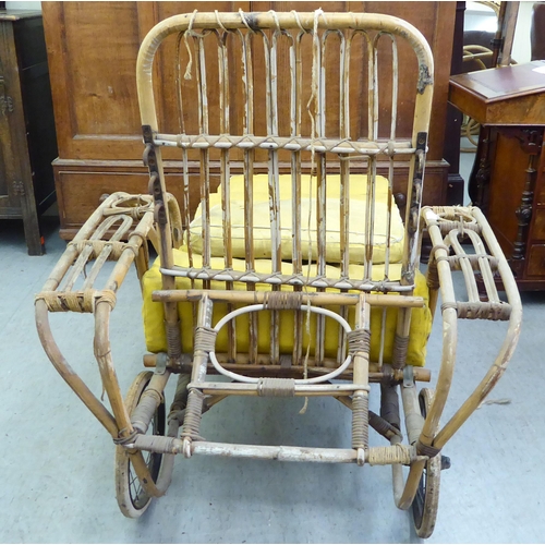 145 - A 1930s colonial design bamboo framed veranda day bed with an adjustable back and spoken wheels