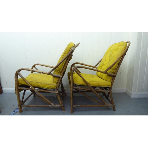 147 - A pair of 1930s colonial design bamboo framed veranda arm chairs, raised on curved legs