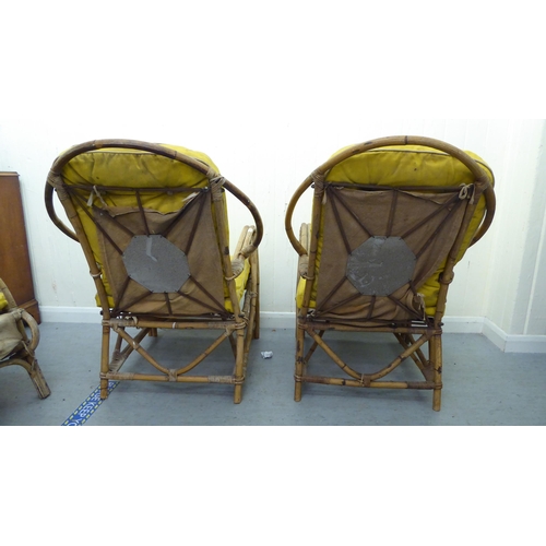 147 - A pair of 1930s colonial design bamboo framed veranda arm chairs, raised on curved legs