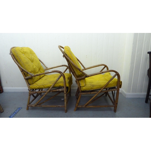 147 - A pair of 1930s colonial design bamboo framed veranda arm chairs, raised on curved legs