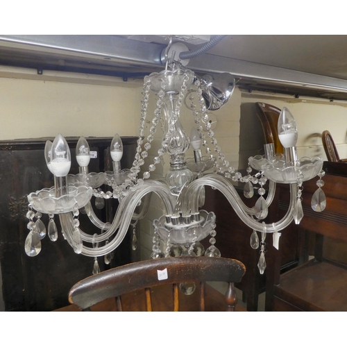 155 - A modern crystal chandelier with six scrolled branches, trailing pendants and beads  24