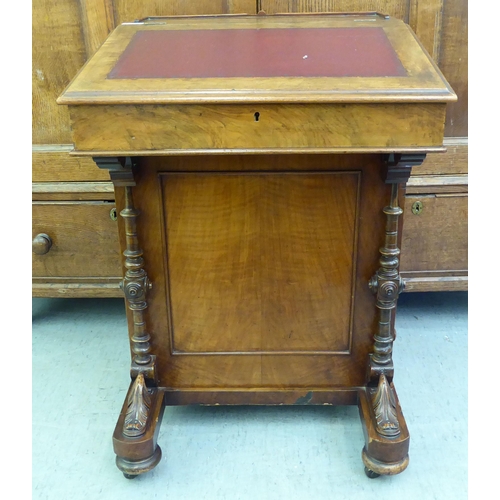 182 - A late Victorian walnut Davenport with a sloping hinged lid, set with a red hide scriber, over a pan... 