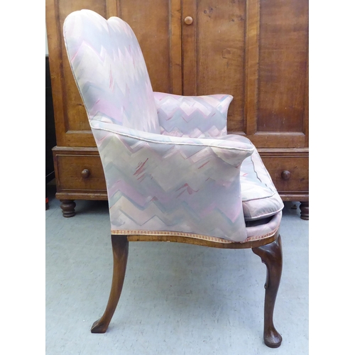 183 - A 1920s mahogany framed two person salon settee, upholstered in a multi-coloured fabric, raised on c... 