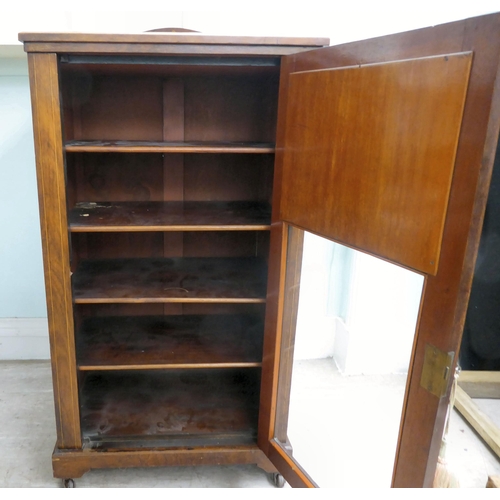 20 - An Edwardian string inlaid rosewood music cabinet with a panelled and glazed door, on a bracket plin... 