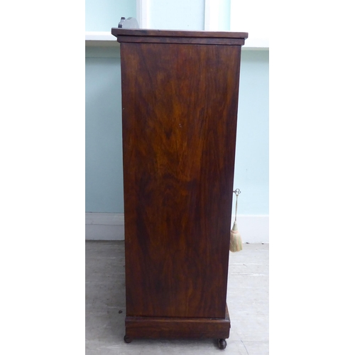 20 - An Edwardian string inlaid rosewood music cabinet with a panelled and glazed door, on a bracket plin... 