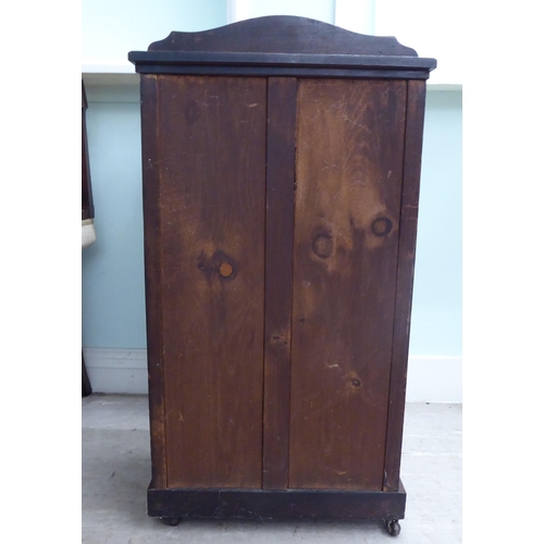 20 - An Edwardian string inlaid rosewood music cabinet with a panelled and glazed door, on a bracket plin... 