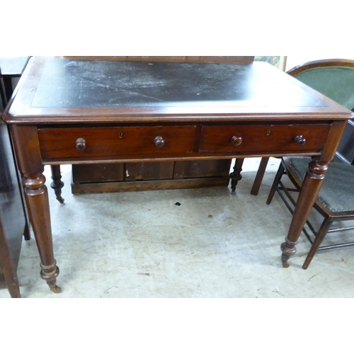 201 - A mid 19thC mahogany writing table, the rexine scriber over a pair of inline drawers with bun handle... 