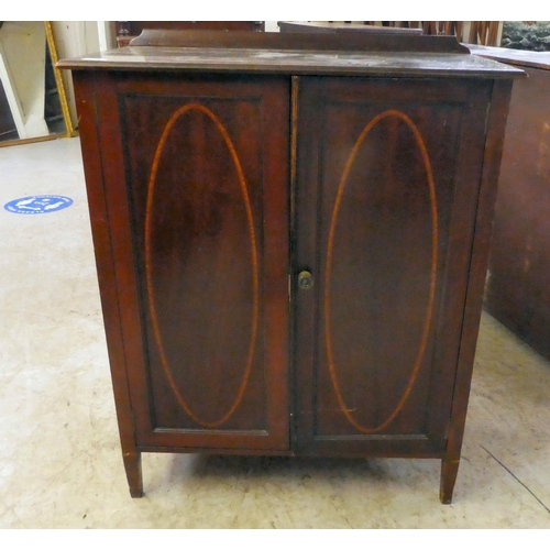 206 - An Edwardian mahogany side cabinet, the shelved interior enclosed by a pair of inlaid, oval panelled... 