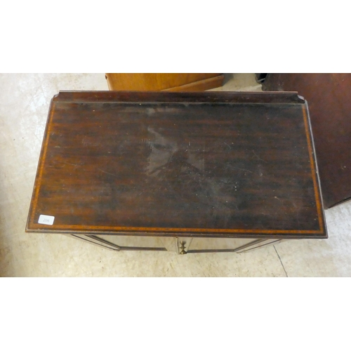 206 - An Edwardian mahogany side cabinet, the shelved interior enclosed by a pair of inlaid, oval panelled... 