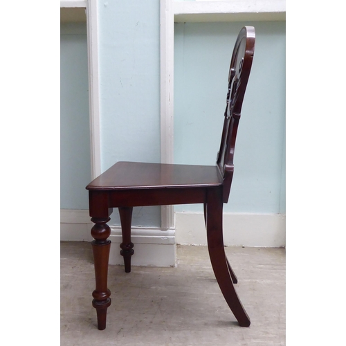 21 - A William IV mahogany panel back hall chair with a solid seat, raised on turned forelegs