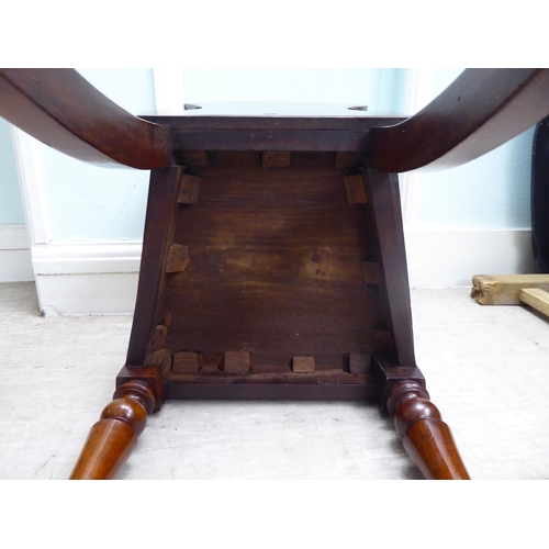 21 - A William IV mahogany panel back hall chair with a solid seat, raised on turned forelegs